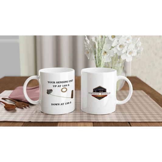 Set of Undeniable Fuel Sending Unit 325ml white ceramic mugs on a dining table, featuring fuel sender design and vintage logo, perfect for garage or kitchen.